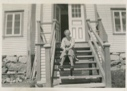 Image of Freida Hettasch sitting on steps of Hettasch home
